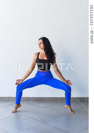 goddess squat or utkata konasana yoga with ukrainian woman making it indoors 107457292
