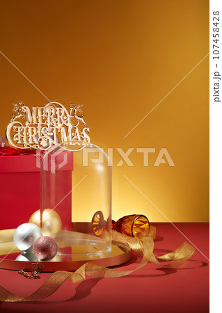 A glass cage placed on golden tray with few baubles in different colors. Front view. Christmas has never failed to attract people with various ways to celebrate in different nations A glass cage placed on golden tray with few baubles in different colors. Front view. Christmas has never failed to attract people with various ways to celebrate in different nations 107458428