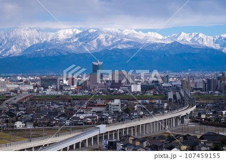 立山あおぐ特等席呉羽山展望台から見た富山市市街地と雪化粧のコ剱岳毛勝三山北アルプス 107459155