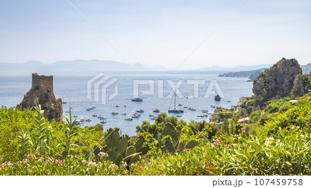 Watchtower with cliffs at The Faraglioni of Scopello rocky peaks Watchtower with cliffs at The Faraglioni of Scopello rocky peaks 107459758