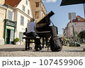 A girl plays the piano on the street of an old European city 107459906