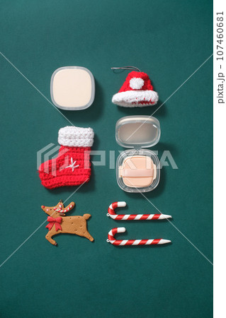 Lovely Christmas decorations are placed on a green background with unlabeled cushion boxes. View from above. Creative ideas for product advertising 107460681