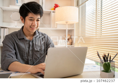 Man sat typing away on a laptop in his office with a determined look on his face, Work from the comfort of home, Male hand pressing on laptop keyboard, Work from home. Man sat typing away on a laptop in his office with a determined look on his face, Work from the comfort of home, Male hand pressing on laptop keyboard, Work from home. 107462237
