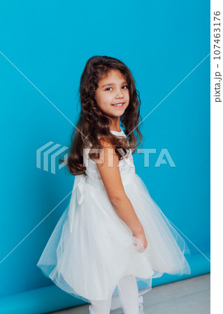 little girl in a white dress on a blue background little girl in a white dress on a blue background 107463176
