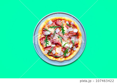 Homemade prosciutto pizza minimalist on a green table Homemade prosciutto pizza minimalist on a green table 107463422