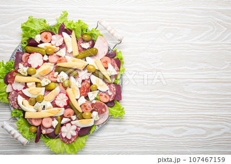 Fiambre, salad of Guatemala, Mexico and Latin America, on large plate top view white wooden background top view. Festive dish for All Saints Day (Day Of The Dead) celebration Fiambre, salad of Guatemala, Mexico and Latin America, on large plate top view white wooden background top view. Festive dish for All Saints Day (Day Of The Dead) celebration 107467159