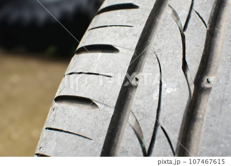 Tire tread wear indicator, Close up of tire with tire tread wear indicator showing on tread grooves. Tire tread wear indicator, Close up of tire with tire tread wear indicator showing on tread grooves. 107467615