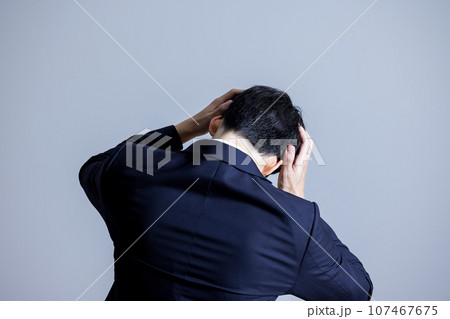 頭を抱える男性の後ろ姿 頭を抱える男性の後ろ姿 107467675