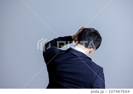 頭を抱える男性の後ろ姿 107467684