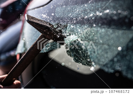 Car thief breaks the car window 107468172