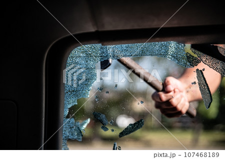 Car thief breaks the car window 107468189