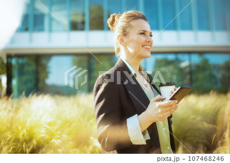 smiling woman worker in business district using smartphone 107468246
