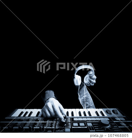 musician hands playing keyboard synthesizer and holding headphone. black and white. music concept musician hands playing keyboard synthesizer and holding headphone. black and white. music concept 107468805
