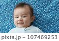 Three month old baby boy smiling and being content on a playmat. 107469253