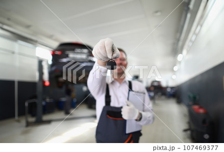 Auto mechanic holds clipboard and car keys 107469377