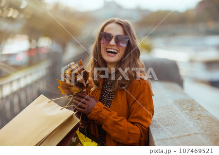 happy woman in orange trench coat happy woman in orange trench coat 107469521