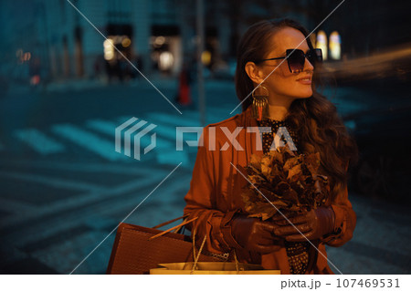 happy trendy female in brown trench coat with shopping bags happy trendy female in brown trench coat with shopping bags 107469531