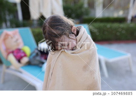 Girl child is wrapped in warm beach towel Girl child is wrapped in warm beach towel 107469885