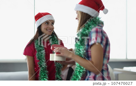 Young woman gives friend a beautiful wrapped present for new year and christmas 107470027