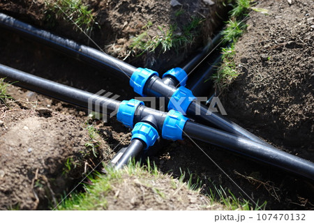 Closeup of plastic pipes of plant watering system in gardens Closeup of plastic pipes of plant watering system in gardens 107470132