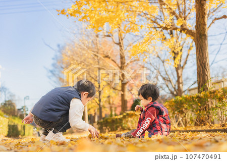 秋の公園で遊ぶ兄弟 107470491