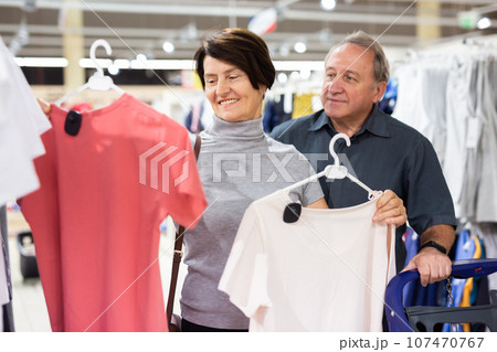 Elderly man and elderly woman choose t-shirt 107470767