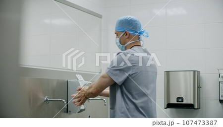 Professional surgeon in uniform washes hands Professional surgeon in uniform washes hands 107473387