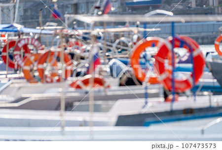 Pier with lifebuoy and boats. Boat for walking. Boat rental. Picture of a boat bow moored to a pier in marina Pier with lifebuoy and boats. Boat for walking. Boat rental. Picture of a boat bow moored to a pier in marina 107473573
