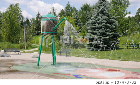 Water splash pad in a park. Water splash pad in a park. 107473732