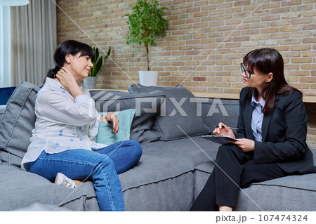 Mature 50s woman having therapy session with psychologist, in office Mature 50s woman having therapy session with psychologist, in office 107474324