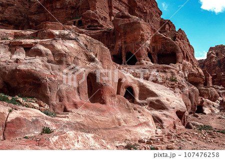 View of the Temples and caves carved into the sandstone rock in the gorge. Petra, Jordan 107476258