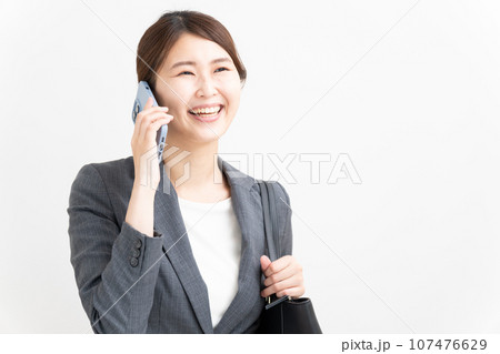 スマートフォンで通話する笑顔のビジネスウーマン 107476629
