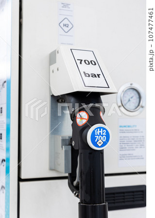 Close-up detail view of hydrogen fuel filler nozzle nozzle adapter car H2 gas filling station in Germany. Refueling vehicle with renewable innovative zero emission product. Future safety technology Close-up detail view of hydrogen fuel filler nozzle nozzle adapter car H2 gas filling station in Germany. Refueling vehicle with renewable innovative zero emission product. Future safety technology 107477461