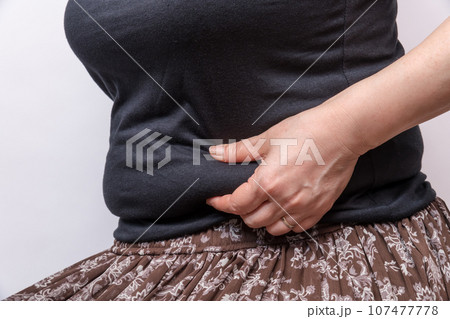 【お腹の肉を摘む主婦】 【お腹の肉を摘む主婦】 107477778
