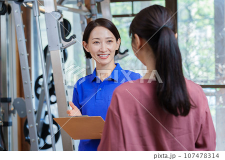 パーソナルジムの説明を受ける女性 107478314