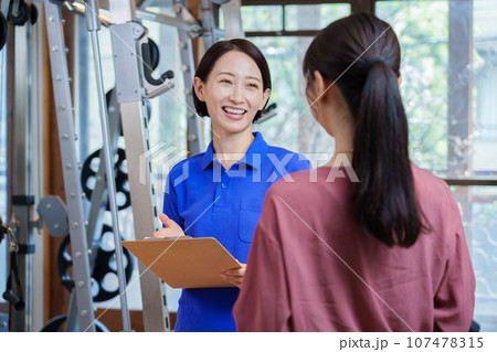 パーソナルジムの説明を受ける女性 107478315