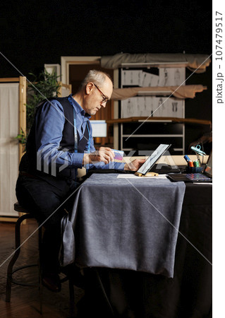 Fashion designer ready to buy sewing materials he needs for upcoming client bespoken comission after finding inspiration online. Elderly suitmaker purchasing tailoring materials with credit card Fashion designer ready to buy sewing materials he needs for upcoming client bespoken comission after finding inspiration online. Elderly suitmaker purchasing tailoring materials with credit card 107479517