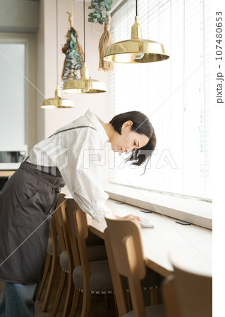 テーブルを拭くカフェの店員 テーブルを拭くカフェの店員 107480653