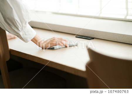 テーブルを拭く女性の手元 107480763