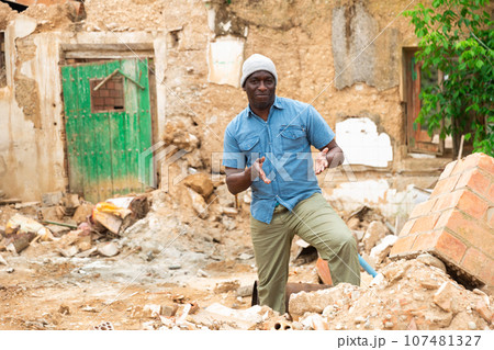 Man near ruined house Man near ruined house 107481327