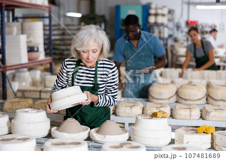 Skillful senior woman ceramist crafring crockery Skillful senior woman ceramist crafring crockery 107481689