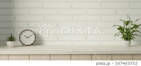 Copy space on a minimalist tabletop against white brick wall with an alarm clock and potted plants. Copy space on a minimalist tabletop against white brick wall with an alarm clock and potted plants. 107483552