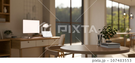 A copy space on a wooden round table in a modern and minimalist spacious office. blurry background. A copy space on a wooden round table in a modern and minimalist spacious office. blurry background. 107483553