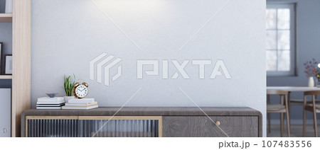 Empty space on a minimal wooden drawer or cabinet against the white wall in a modern living room. Empty space on a minimal wooden drawer or cabinet against the white wall in a modern living room. 107483556