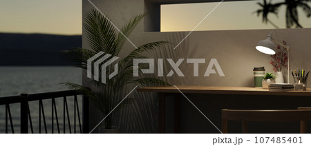 Modern workspace at night, copy space on a table and balcony with a beautiful sunset view Modern workspace at night, copy space on a table and balcony with a beautiful sunset view 107485401