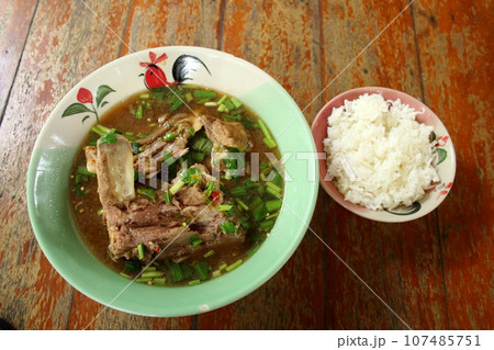 Pork backbone sour soup and rice on wood table. 107485751