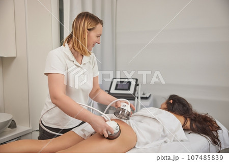 beauty care, modern medical, LPG massage. Body massage with vacuum, problem areas slimming, body care professional equipment, low ph massage procedure, anti-cellulite roller vacuum in medical salon 107485839