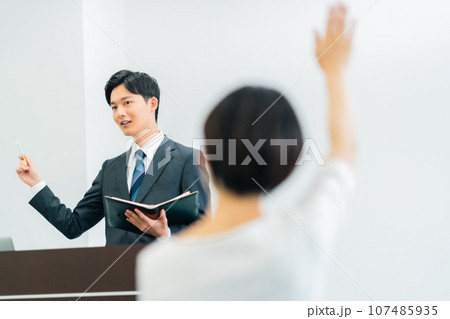 資料をもとに壇上で解説するセミナー中の講師 107485935