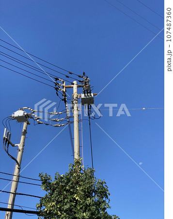 青空の下の電柱と電線 107487360