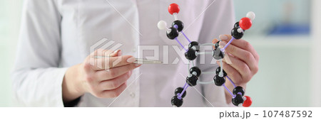 Lab assistant demonstrates molecule model close view 107487592
